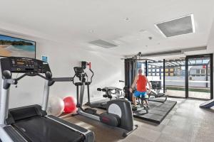 a man in a gym with two exercise bikes at Modern Spacious City Pad with Rooftop Pool and Gym in Sydney