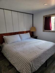 a bedroom with a large bed with a striped comforter at Greer Point Trails End Cabins in Greer