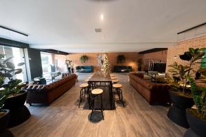 a large room with couches and a table and chairs at FULTON Business Luxury HOTEL in Guadalajara