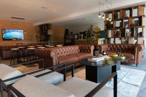 a living room with leather couches and a bar at FULTON Business Luxury HOTEL in Guadalajara
