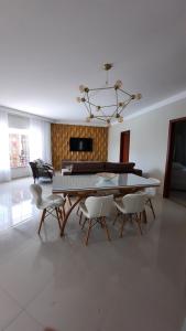 a dining room with a table and chairs and a chandelier at Casa de Praia in Porto Seguro