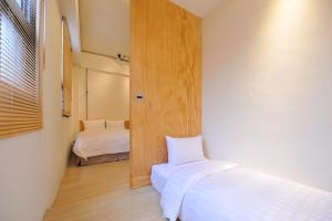a small bedroom with a bed and a window at Home Rest Hotel 2 in Taitung City
