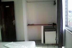 a room with a desk and a bed and a window at Pousada Temporada Atlântica in Fortaleza