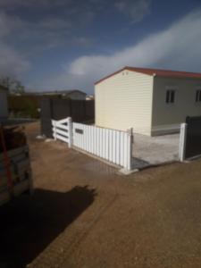 a white fence in front of a white house at Mobilhome in Pornic
