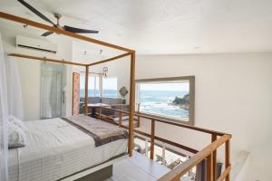 a bedroom with a view of the ocean at Villa Aikia (Adults Suites A/C) in Zipolite