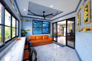 a living room with an orange couch and windows at Kerton Hostel in Lamai