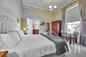 
a bedroom with a large bed and a large window at Arundels Boutique Accommodation in Fremantle
