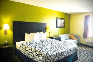 um quarto de hotel com uma cama e um sofá em Days Inn by Wyndham Park City Kansas em Park City