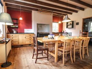 a large kitchen with a wooden table and chairs at Llysgwaun in Fishguard