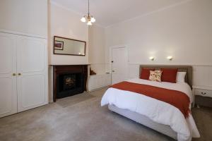 a bedroom with a bed and a fireplace at Windarra on High in Launceston