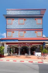 a blue building with tables and chairs on a street at Kerton Hostel in Lamai