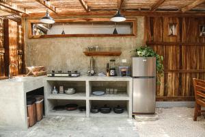 a kitchen with a sink and a refrigerator at Zeneidas Surf Garden in Santa Teresa Beach