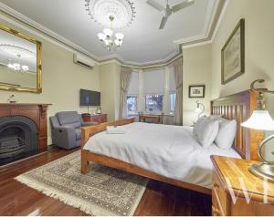 
a bedroom with a large bed and a fireplace at Arundels Boutique Accommodation in Fremantle
