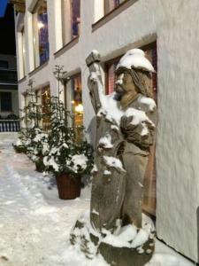 a statue covered in snow next to a building at POD TĘŻNIĄ in Szczyrk +8 photos