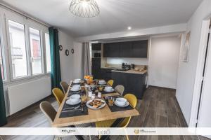 a dining room with a table and chairs and a kitchen at La parenthèse du Tourmalet -draps inclus, local ski avec sèche chaussures in Luz-Saint-Sauveur