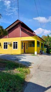 a yellow and red building with a red roof at DYANA INN TRANSIT ROOMS in Kota Bharu