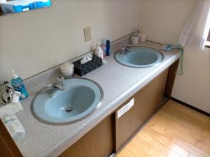 a bathroom with two sinks in a room at Guesthouse Aozora Blue Sky in Myoko