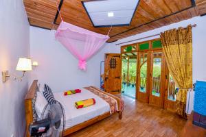 a bedroom with a bed with an umbrella hanging from the ceiling at Astral Zone Cottage ELLA in Ella