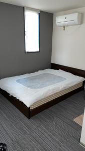 a large bed in a room with a window at はらビジネス旅館 in Wakayama
