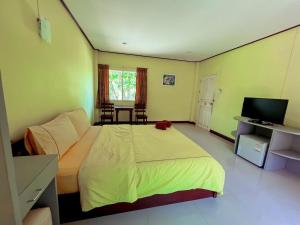 een slaapkamer met een groot bed en een televisie bij Klangsuan Resort กลางสวน รีสอร์ท แกลง in Ban Phlong Chang Phuak