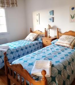 1 dormitorio con 2 camas y mesa con lámpara en Casa do Pombar en Valdeorras 