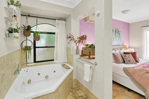a bathroom with a tub next to a bed at Villa Blue - Coastal Family Escape in Palm Cove