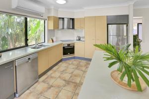 a kitchen with stainless steel appliances and a potted plant at Villa Blue - Coastal Family Escape in Palm Cove