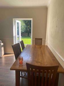 a dining room table with chairs and a candle on it at 3 bedroom bungalow set in private woodlands. in Upminster