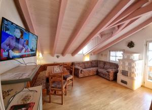 sala de estar con sofá y TV en Cesa Alegra, en Campestrin