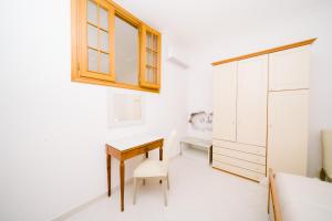 a white room with a desk and a cabinet at Rosemary Holiday House in Conca dei Marini +33 photos