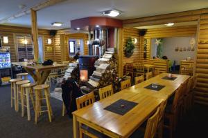 um restaurante com mesas e cadeiras de madeira e um bar em Ubytování Skipot em Potŭčky