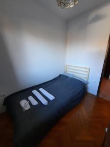 a bedroom with a bed with two slippers on it at Apartments Mateo in Zagreb