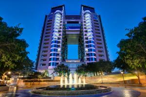 un grand bâtiment avec une fontaine devant lui dans l'établissement Dukes The Palm, a Royal Hideaway Hotel, à Dubaï