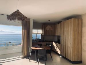 プエルト・デ・サンティアゴにあるSpacious, Light & Cozy Apartments with Ocean Viewsの海の景色を望むキッチン(テーブル付)
