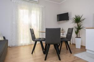 stół z 2 krzesłami i telewizor w obiekcie Apartments Star w mieście Zadar