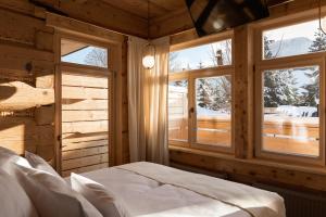 a bedroom with two windows and a bed in it at Villa Milimani - stuletnia, folk & butique, adults only in Zakopane