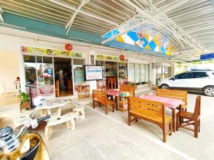 un restaurante con bancos y mesas de madera y un coche en Common Living, en Chiang Mai