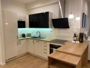 a kitchen with white cabinets and a counter top at Ultralux magnolia city center bestern in Szeged
