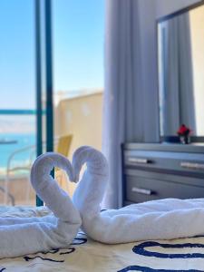 two towel swans forming a heart on a bed at Star of Tiberias in Tiberias