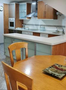eine Küche mit einem Holztisch und einer Küchentheke in der Unterkunft Apartamento Camariñas in Camariñas