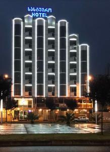 a hotel with a lit up building at night at Hotel ''Premium Palace'' in Batumi