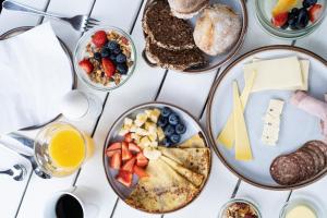 a table with plates of breakfast food on it at Langebjerg Pension & Spisested in Allinge