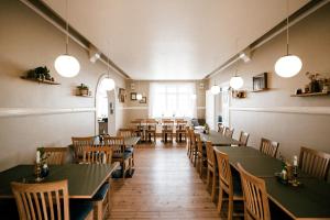 a dining room with tables and chairs and lights at Langebjerg Pension & Spisested in Allinge