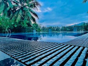 a swimming pool with palm trees in the background at Travellers Halt in Ratnapura