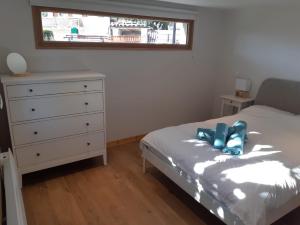 a bedroom with a bed and a dresser and a window at Appartement neuf, une chambre avec parking in Séez