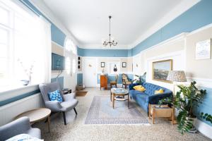 a living room with blue walls and blue furniture at Langebjerg Pension & Spisested in Allinge
