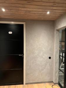 um quarto com uma porta preta e uma parede cinzenta em B&B Driel em Driel