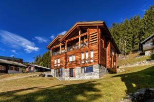 a large wooden house on a hill with trees at Chalet Altishofen in Riederalp