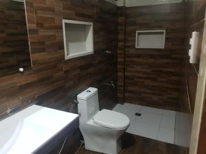 a bathroom with a white toilet and a sink at B&S pension house in Dipolog