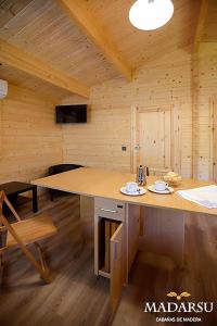 Habitación de madera con una mesa grande en una cabaña en Cabañas Madarsu, en Vigo de Sanabria